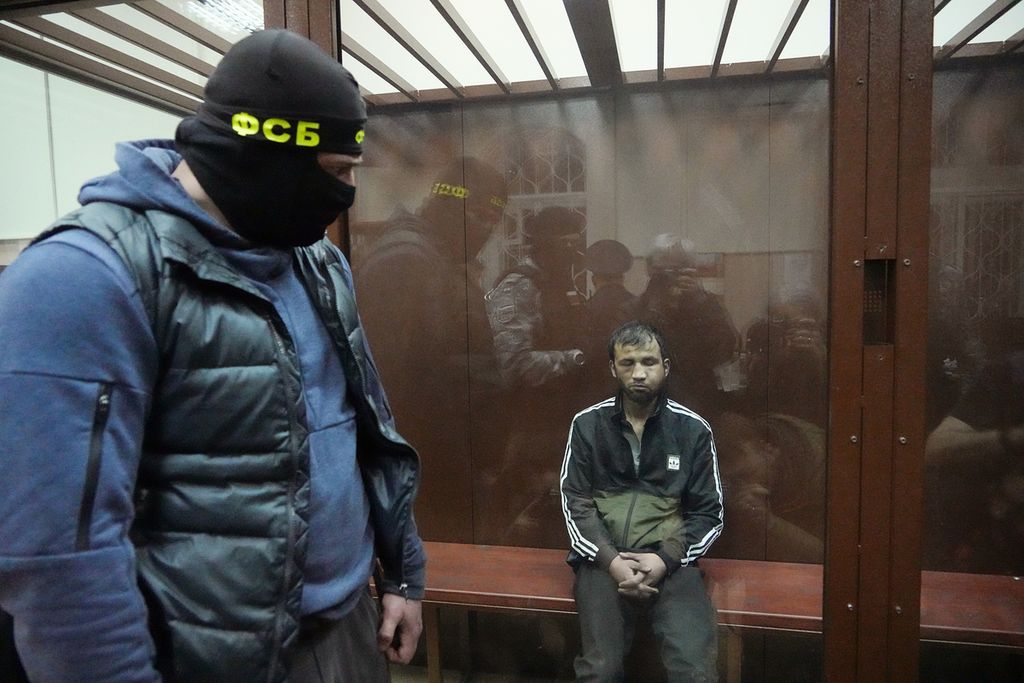 Aparat keamanan Rusia menjaga Shamsidin Fariduni, salah satu terduga pelaku penembakan di Balai Kota Crocus di Moskwa, Rusia, saat menjalani sidang awal di Pengadilan Distrik Basmanny, Moskwa, Minggu (24/3/2024). 