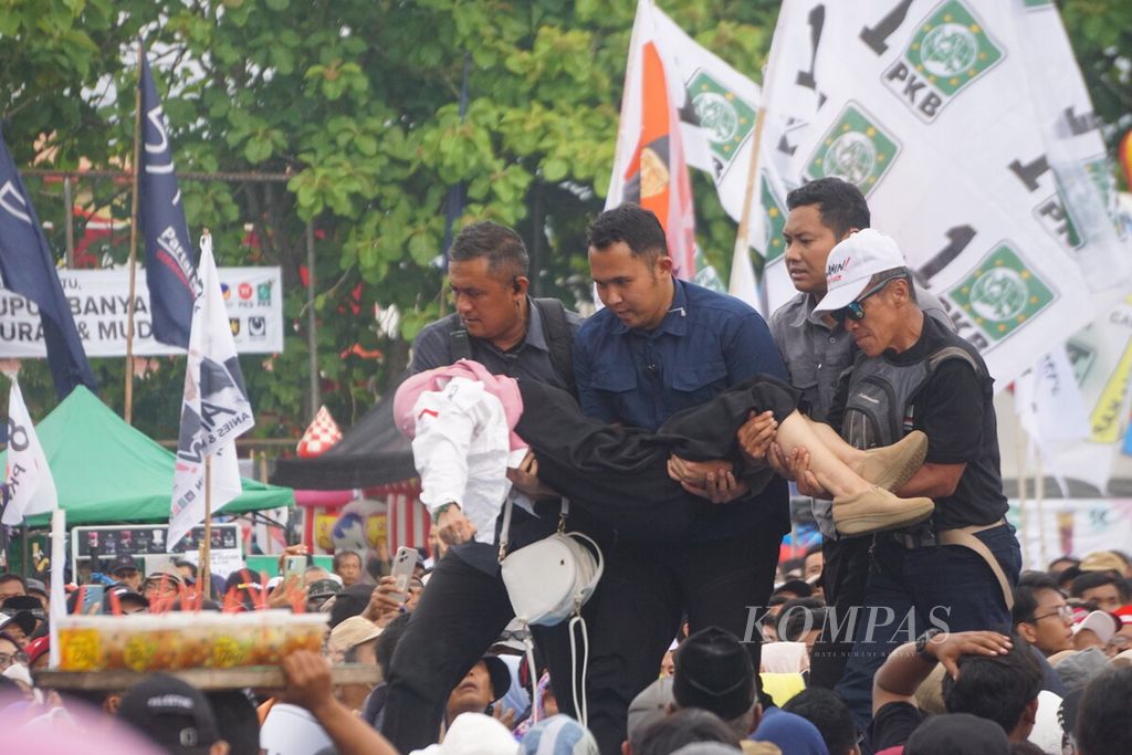 Petugas menggotong salah satu pengunjung yang pingsan dalam kampanye terbuka calon presiden Anies Baswedan di Cilacap, Jawa Tengah, Rabu (24/1/2024).
