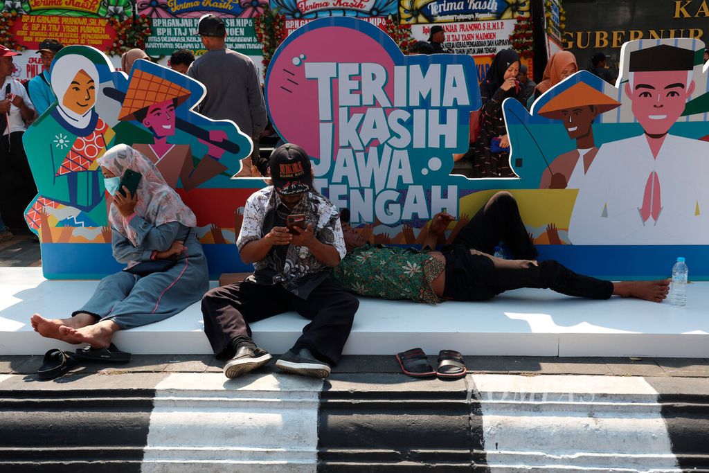 Warga menunggu acara kesenian dan pidato perpisahan Ganjar Pranowo sebagai Gubernur Jawa Tengah di Jalan Pahlawan, Kota Semarang, Jawa Tengah, Selasa (5/9/2023).