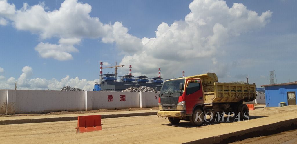 Truk melintas di depan area pabrik pengolahan dan pemurnian (<i>smelter)</i> berbasis nikel milik PT Virtue Dragon Nickel Industry di Konawe, Sulawesi Tenggara, Februari 2019.