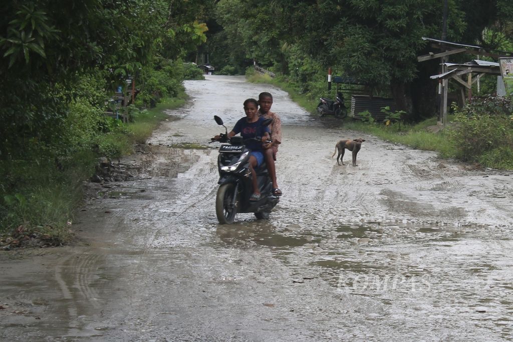 Warga harus waspada ketika melewati jalan jalur Sentani-Depapre di Kabupaten Jayapura, Papua, yang berlubang dan licin ketika hujan.