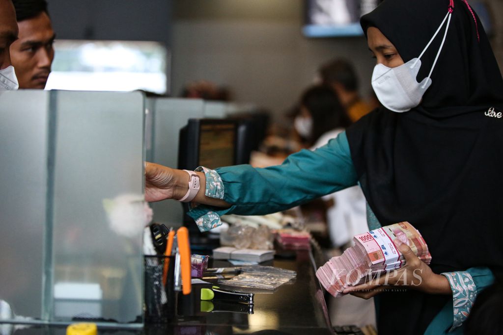 Petugas mempersiapkan uang rupiah di tempat penukaran valuta asing PT Valuta Inti Prima di Jakarta, Jumat (16/2/2024).