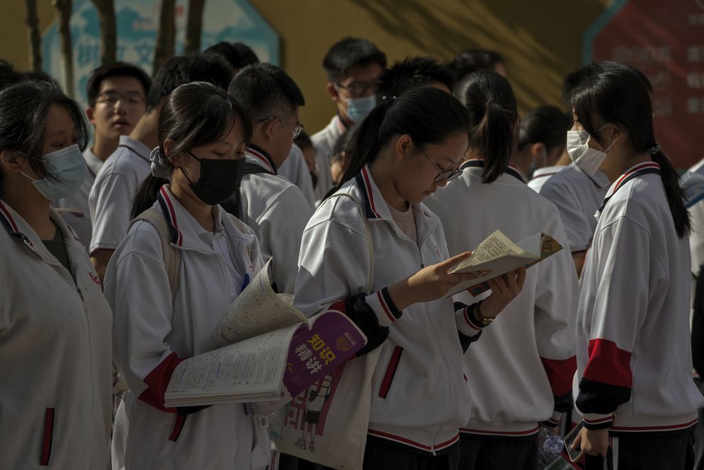 Siswa mempelajari buku pelajaran di luar sekolah sebelum hari pertama ujian masuk perguruan tinggi nasional China yang dikenal sebagai <i>gaokao</i>, di Beijing, 7 Juni 2023. Lebih dari 12 juta siswa sekolah menengah di seluruh China mengikuti ujian masuk perguruan tinggi tahunan.