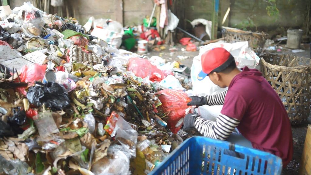 Petugas memilah sampah di TPS Benua Lestari, Tangerang, Banten, pada Senin (25/4/2022). Di TPS ini, sampah makanan dipilah untuk dijadikan pakan untuk maggot, sedangkan sampah anorganik seperti tutup botol dan gelas plastik disisihkan untuk dijual kembali ke industri daur ulang.