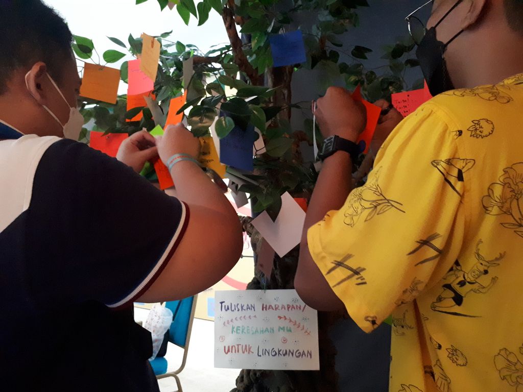 Salah satu pengunjung yang datang dan menuliskan harapan untuk lingkungan di Youth Festival Greenpeace Indonesia 2022 di Kuningan, Jakarta, Jumat (28/10/2022).