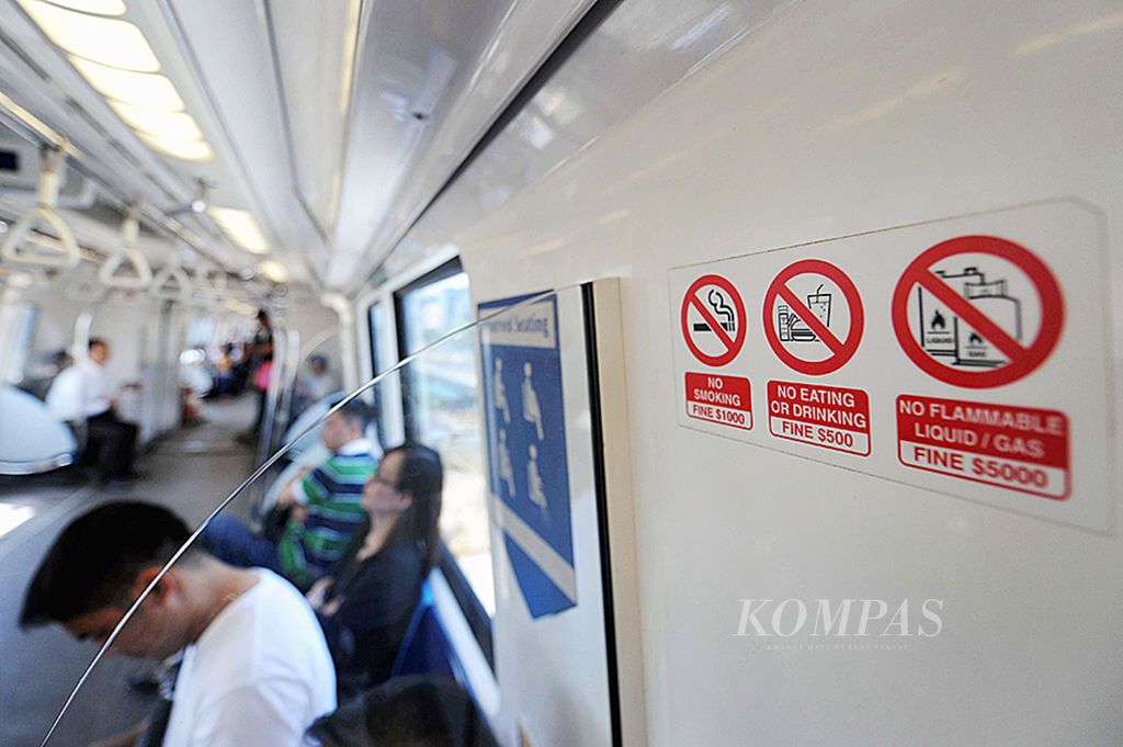 Larangan berperilaku bagi masyarakat terpasang di dalam kereta MRT, Singapura, Jumat (29/5).