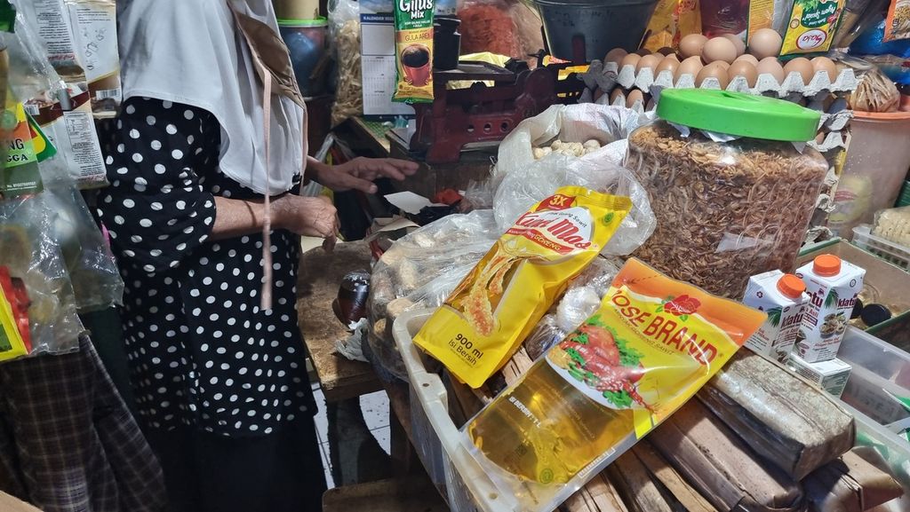 Seorang pedagang di Pasar Cihapit, Kota Bandung, Jawa Barat, menunjukkan sejumlah kemasan minyak goreng, Kamis (20/1/2022). Di pasar ini, harga minyak goreng masih berkisar Rp 20.000 per liter.