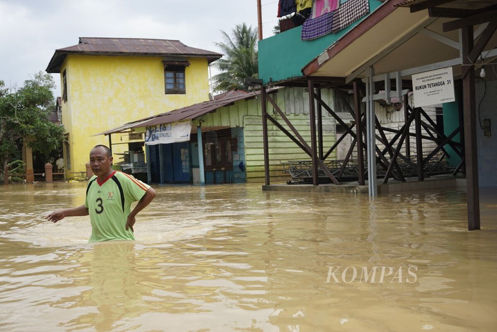 Seorang warga melintas permukiman yang terendam banjir di RT 031 Kelurahan Damai, Kecamatan Balikpapan Kota, Balikpapan, Kalimantan Timur, Senin (27/7/2020). Hujan intensitas tinggi yang turun sekitar 8 jam membuat 150 keluarga terdampak banjir.