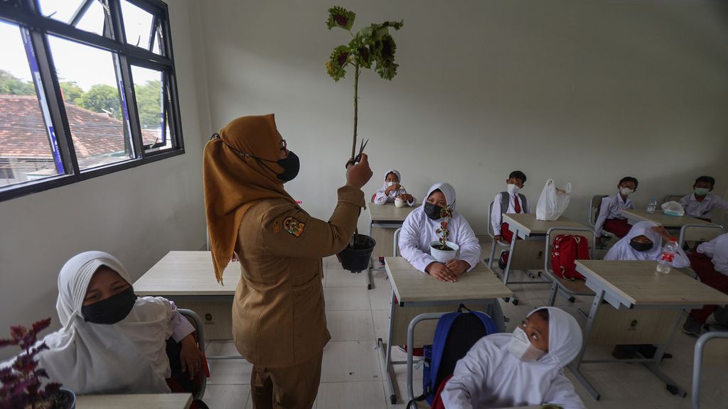 Guru mengajarkan cara perbanyakan tanaman kepada muridnya di SD Negeri Bumijo, Yogyakarta, Senin (17/1/2022).
