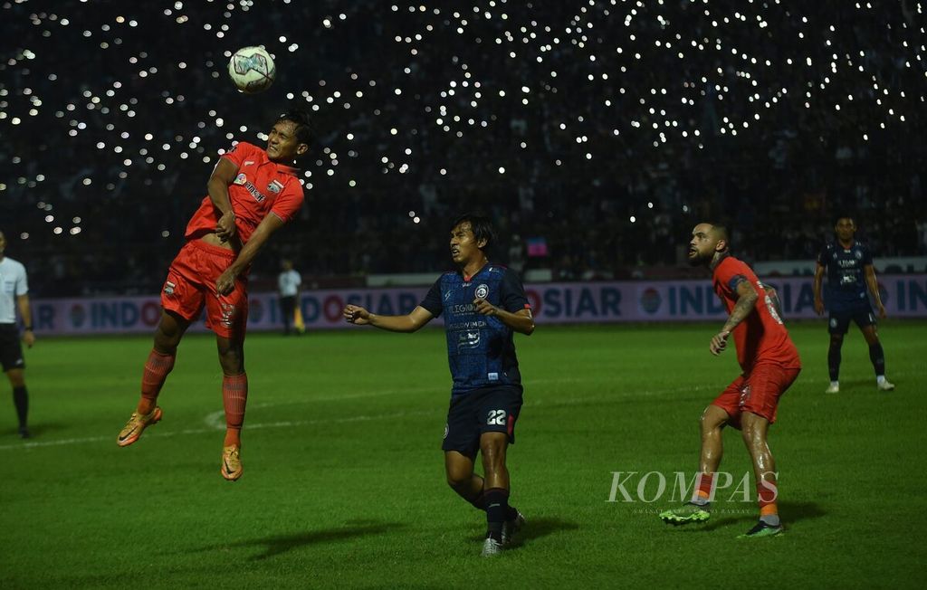 Pemain Arema FC, Hanis Sagara (tengah), berebut bola dengan pemain Borneo FC, Hendro Siswanto, dalam Laga pertama final turnamen Piala Presiden 2022 di Stadion Kanjuruhan, Kabupaten Malang, Kamis (14/7/2022).