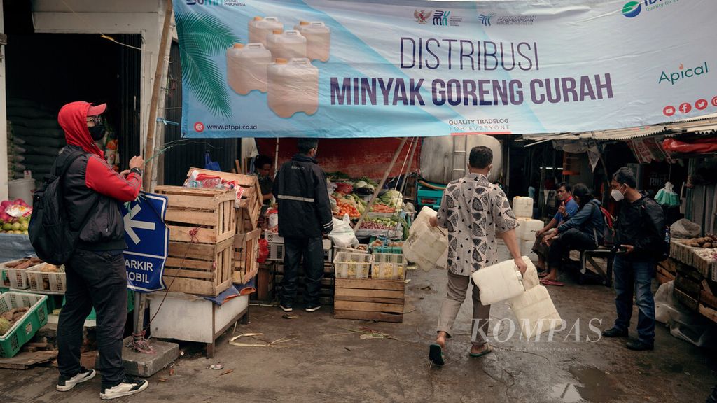 Pedagang membawa jeriken kosong dalam distribusi mingguan minyak goreng curah di Pasar Perumnas Klender, Jakarta Timur, Jumat (25/2/2022). PT Perusahaan Perdagangan Indonesia (Persero) mendistribusikan minyak goreng curah di sejumlah pasar tradisional di Jakarta. Satu truk tangki membawa 8.000 liter minyak goreng curah. Pedagang membeli minyak goreng curah Rp 10.500 per liter dan menjualnya kembali Rp 12.000 hingga Rp 13.000.