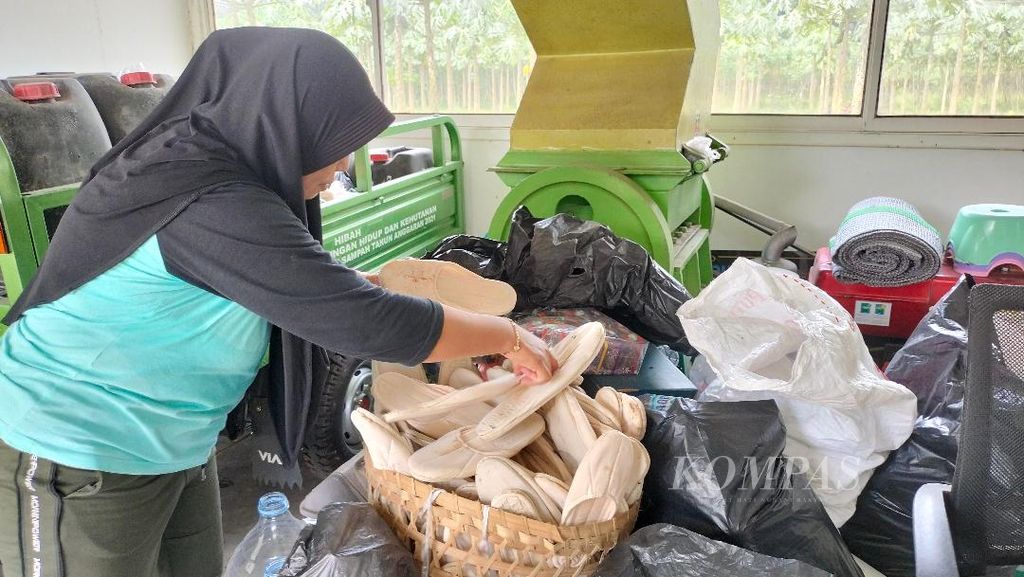 Hidayatul Rahmawati (47) menunjukkan aktivitas memilah sampah yang diterimanya dari hotel di  Bank Sampah Bumi Hijau di Desa Bumiharjo, Kecamatan Borobudur, Kabupaten Magelang, Jawa Tengah, Rabu (14/12/2022).