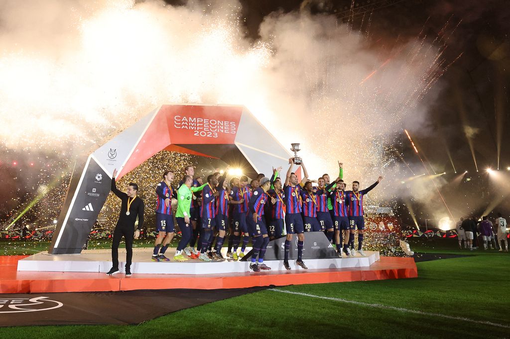 Para pemain Barcelona merayakan kemenangan di atas podium pada pertandingan sepak bola final Piala Super Spanyol 2022/23 antara Real Madrid dan Barcelona di Stadion Internasional King Fahd di Riyadh, Arab Saudi, Senin (16/1/2023) dini hari WIB.