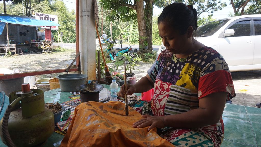 Lisa Pratami, pembatik, mencanting atau menorehkan malam cair pada kain bermotif batik di rumah produksi batik tulis warna alam Mahkota, Bangkalan, Pulau Madura, Jawa Timur, Sabtu (23/7/2022). 