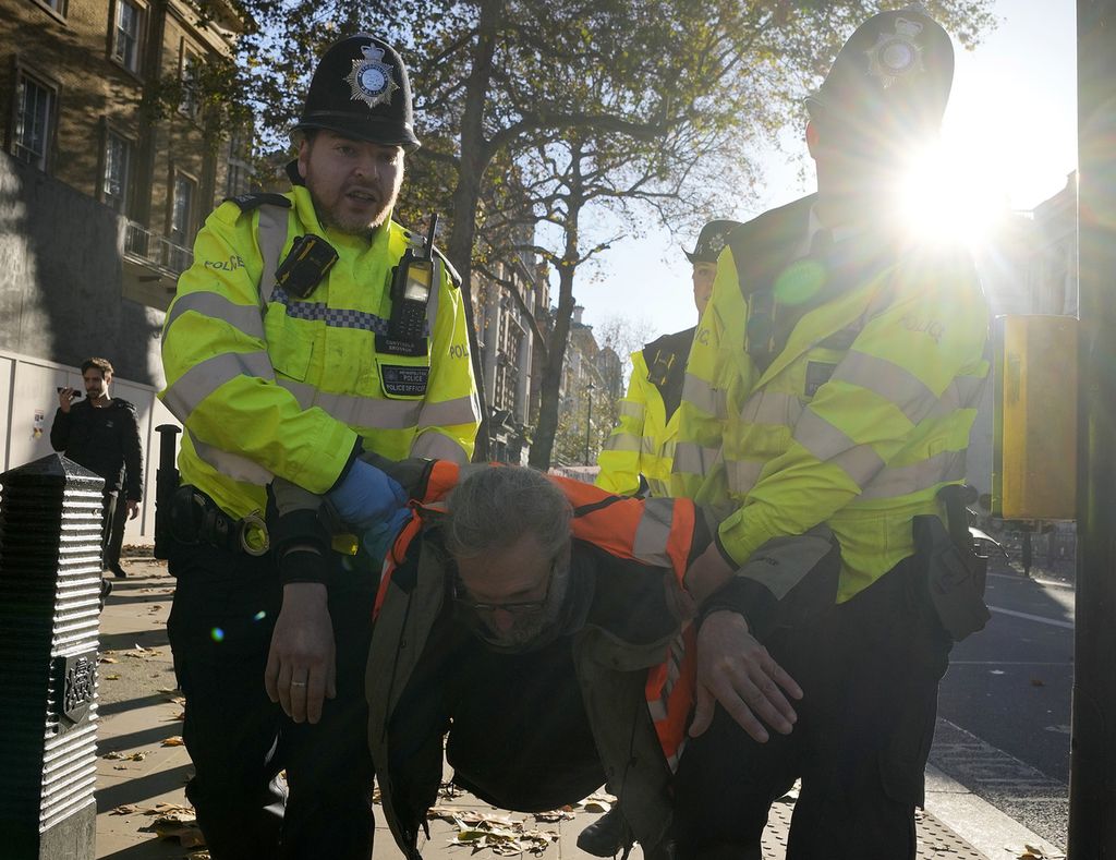 Pengunjuk rasa dari kelompok Just Stop Oil ditangkap polisi di London, Inggris, November 2023. Inggris menerapkan serangkaian aturan yang melarang unjuk rasa. Pembatasan itu dinilai bisa memberangus demokrasi.