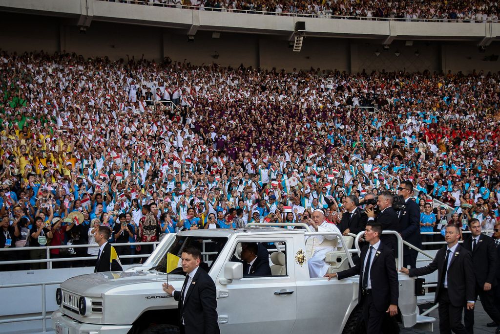 Paus Fransiskus menyapa umat yang berkumpul di Stadion Gelora Bung Karno (GBK), Jakarta, dengan kendaraan terbuka Kamis (5/9/2024). 