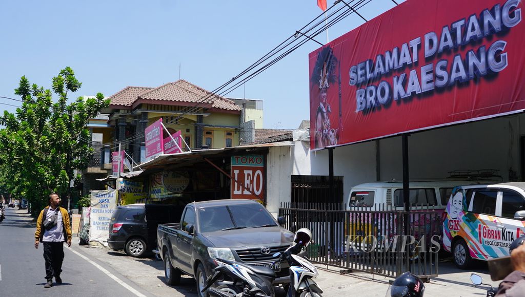 Seorang warga melintas sambil melihat baliho bertuliskan ”Selamat Datang Bro Kaesang” di Kantor DPD PSI Kota Surakarta, Jawa Tengah, Kamis (21/9/2023).