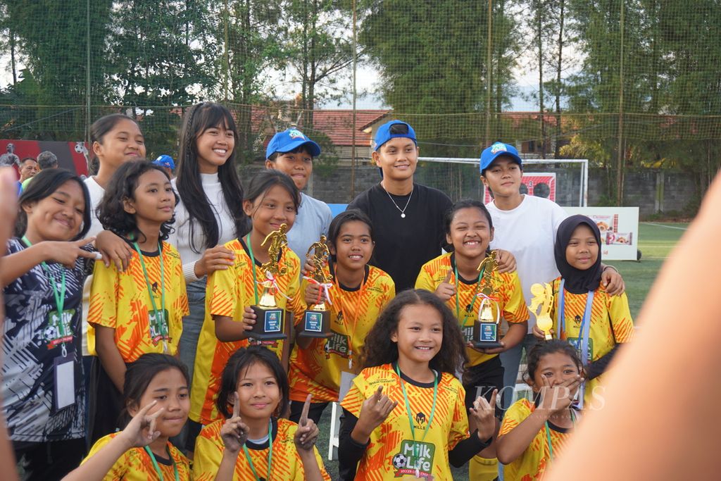 Para pesepak bola putri belia berfoto bersama para pemain timnas sepak bola putri setelah gelaran turnamen sepak bola putri antarsekolah dasar dan madrasah ibtidaiyah, MilkLife Soccer Challenge, di lapangan Progresif Sport Center, Bandung, Jawa Barat, Minggu (23/6/2024).