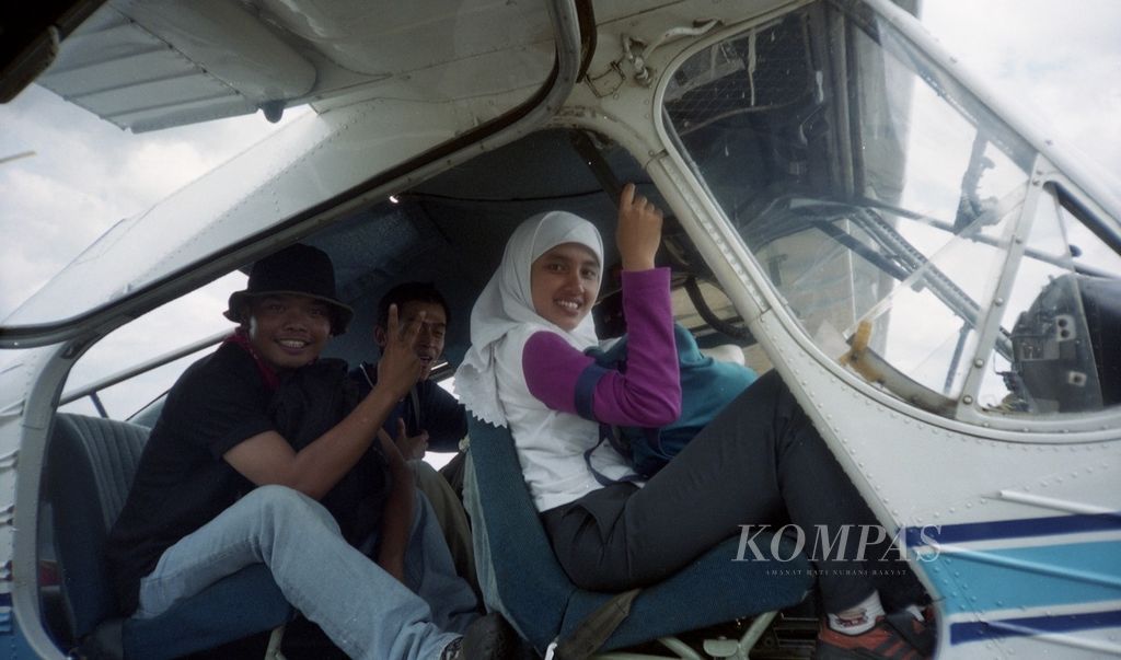 Calon wartawan <i>Kompas</i> dari Kelompok Tajuk-4, Khairina Nasution (kanan) bersama Taufik Zulkarnaen (kiri), mencoba pesawat latih terbang layang di Lapangan Terbang Pondok Cabe, Minggu (19/1/2003).