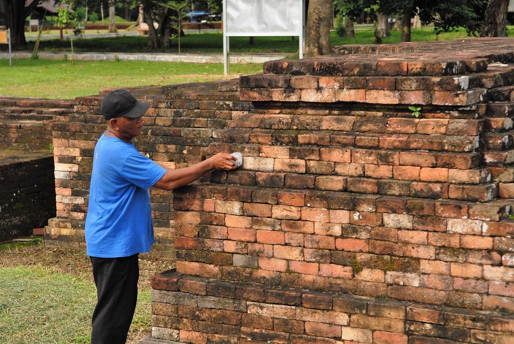 Seorang petugas tengah merawat bata kuno di Kompleks Candi Gumpung di dalam Kawasan Cagar Budaya Nasional Muaro Jambi, 2020.