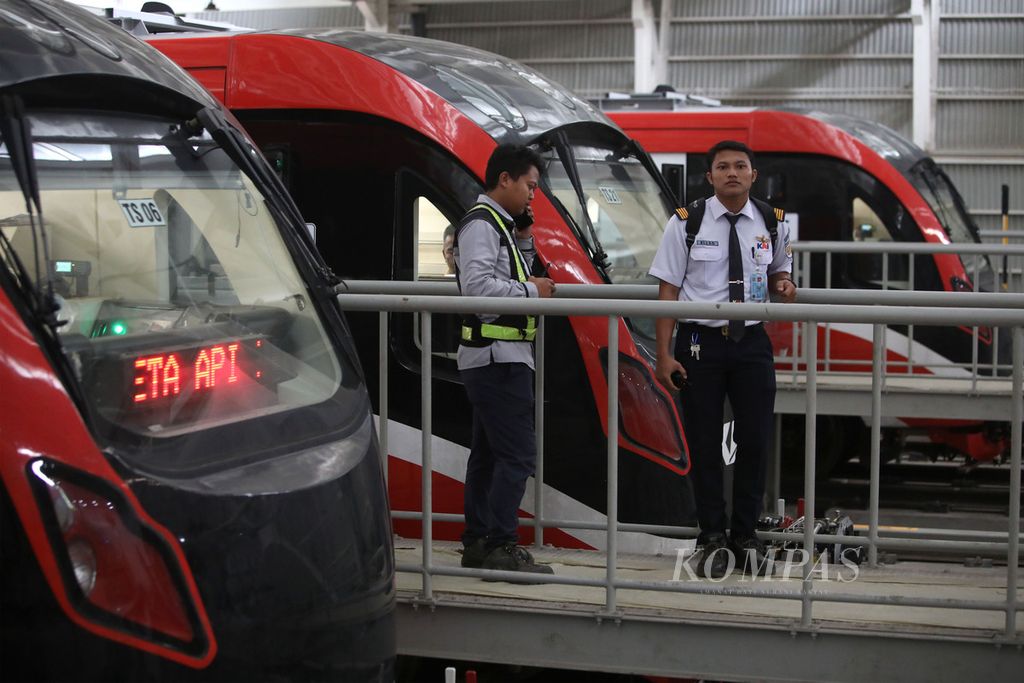 Petugas berbincang di dekat rangkaian moda lintas rel terpadu (LRT) Jabodebek di Depo LRT Jati Mulya, Bekasi, Kamis (6/7/2023). LRT Jabodebek akan melakukan uji coba dengan penumpang secara terbatas atau <i>soft launching </i>pada 12 Juli 2023 dan pada 18 Agustus 2023 akan dioperasikan berbayar. LRT Jabodebek memiliki 6 kereta atau gerbong. Adapun kapasitasnya sekitar 1.308 penumpang di mana 174 penumpang duduk dan sisanya berdiri.  