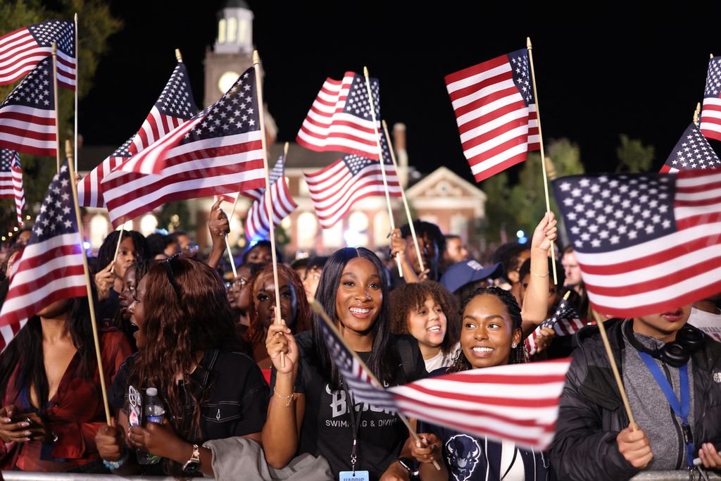 Para pendukung Partai Demokras AS membawa bendera Amerika Serikat dalam malam pemilihan presiden di Howard University in Washington DC, Selasa (5/11/2024). 