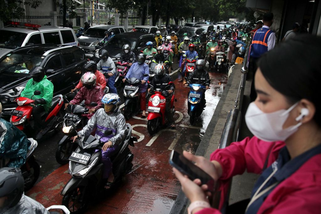 Pengendara sepeda motor terjebak kemacetan di Jalan Tentara Pelajar di sekitar Stasiun Palmerah, Jakarta, Selasa (21/2/2023). Kepadatan kendaraan bermotor menyumbang bau khas kota, yaitu emisi gas buang. 