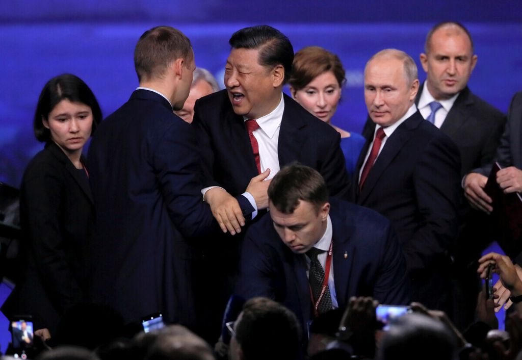 Presiden China Xi Jinping (tengah) bereaksi saat menyapa peserta, saat Presiden Rusia Vladimir Putin (ke-2 dari kanan) dan Presiden Bulgaria Rumen Radev (kanan) berdiri di dekatnya, setelah sesi Forum Ekonomi Internasional St. Petersburg (SPIEF) di Rusia, 7 Juni 2019. 
