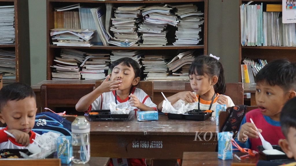 Para siswa melahap sajian makanan dalam uji coba program makan bergizi gratis di SD Negeri Tugu 120 Surakarta, Kota Surakarta, Jawa Tengah, Kamis (25/7/2024). 