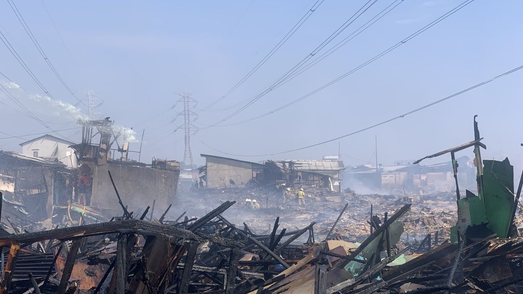 Sejumlah personil pemadam kebakaran melakukan upaya pendinginan di lokasi kejadian di Kampung Nelayan Muara Angke RT 12 RW 22 Tembok Bolong, Penjaringan, Jakarta Utara, Sabtu (22/4/2023).