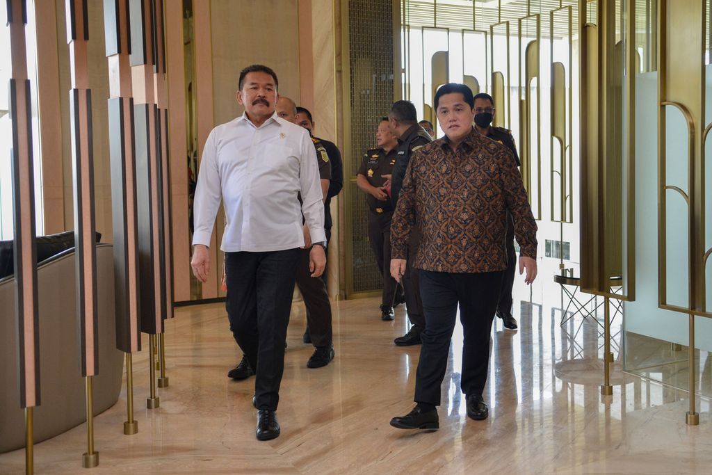 Jaksa Agung Sanitiar Burhanuddin (kiri) didampingi Menteri Badan Usaha Milik Negara Erick Thohir berjalan menuju tempat konferensi pers di Gedung Kejaksaan Agung, Jakarta, Senin (6/3/2023). 