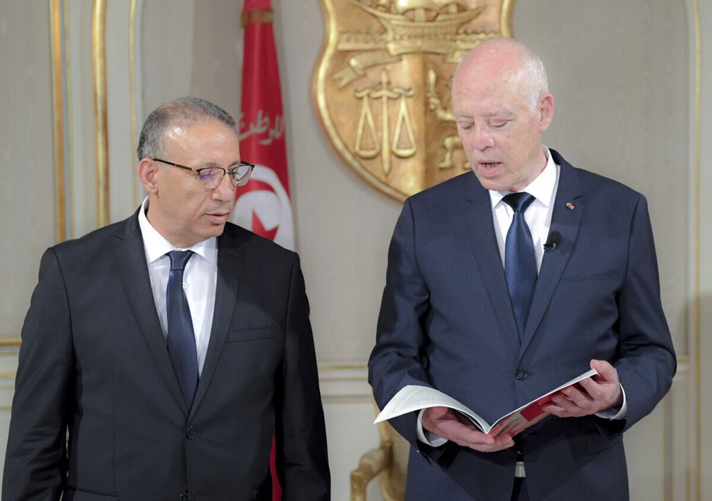 Presiden Tunisia Kais Saied (kanan) berbicara dengan Pelaksana Tugas Menteri Dalam Negeri Tunisia Ridha Gharsallaoui seusai upacara pelantikannya di Istana Kepresidenan Carthage, luar Tunis, Tunisia, 29 Junli 2021. 