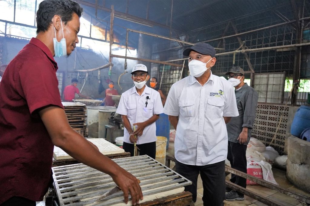 Menteri Koperasi dan UKM Teten Masduki (kanan) saat meninjau pabrik tahu dan tempe di Sumedang, Jawa Barat, Selasa (15/2/2022). Pabrik ini menggunakan kedelai sebagai bahan bakunya. 