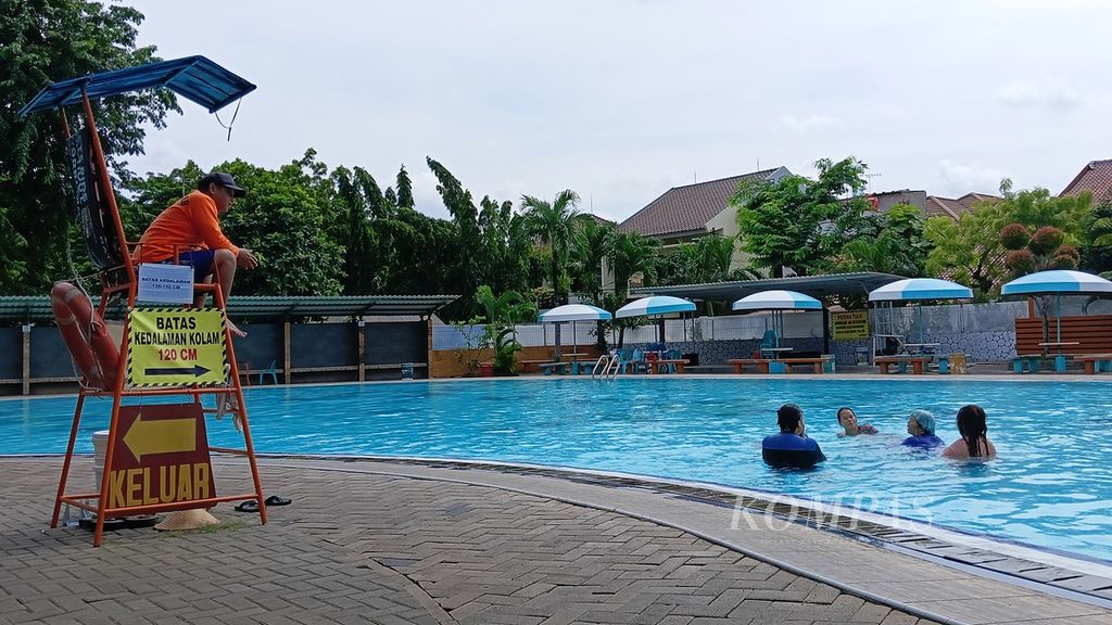 Petugas keselamatan mengawasi pengunjung yang berenang di kolam renang Taman Tirta Mas (Palem Indah), Pondok Kelapa, Duren Sawit, Jakarta Timur, Selasa (13/2/2024).