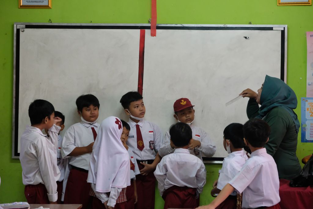 Salah satu orangtua murid mengajar siswa di SDN Pondok Cina 1, Depok, Jawa Barat, Senin (12/12/2022). 