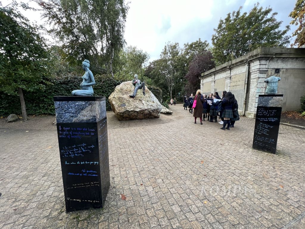Sejumlah murid tengah mengunjungi monumen Oscar Wilde yang terletak di sudut barat Merrion Square Park, Dublin, Irlandia, Senin (23/10/2023). Patung ini dipahat oleh pematung Irlandia, Danny Osborne dan perlu waktu 2,5 tahun, untuk menyelesaikannya.