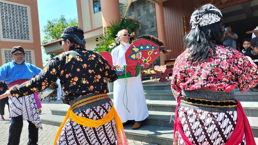 Romo Gregorius Suprayitno Pr (berjubah putih) menari <i>jathilan</i> bersama puluhan penari lainnya di halaman Gereja Katolik St Mikael seusai misa Paskah, Minggu (9/4/2023), di Kabupaten Magelang, Jawa Tengah. 