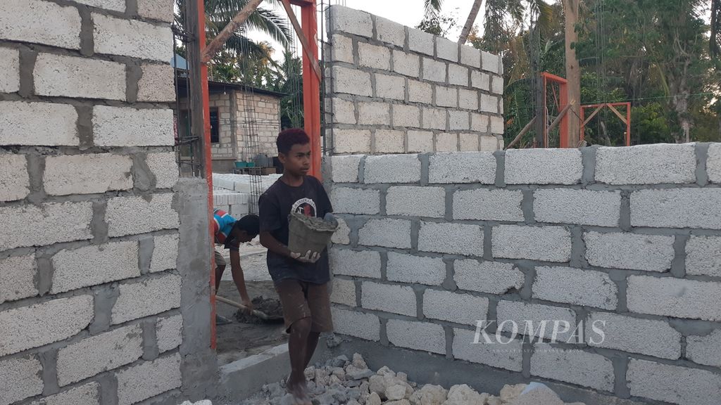 Rio (13), siswa salah satu sekolah menengah pertama di Kabupaten Timor Tengah Utara, menjadi buruh bangunan di Kota Kupang, Nusa Tenggara Timur, Kamis (16/9/2021). 