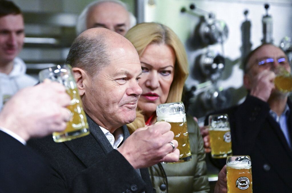 Kanselir Jerman Olaf Scholz minum bir dalam kunjungannya ke pabrik bir Gold Ochsen di Ulm, Jerman, 16 Januari 2023. 