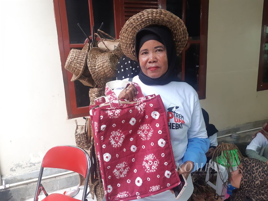 Ruslina, warga 1 Ilir, Kecamatan Ilir Timur II, Palembang, Sumatera Selatan, menunjukkan hasil karyanya berupa tas dan topi yang terbuat dari batang eceng gondok, Jumat (3/3/2023). Dengan cara ini, diharapkan sampah dapat dikelola dengan baik.