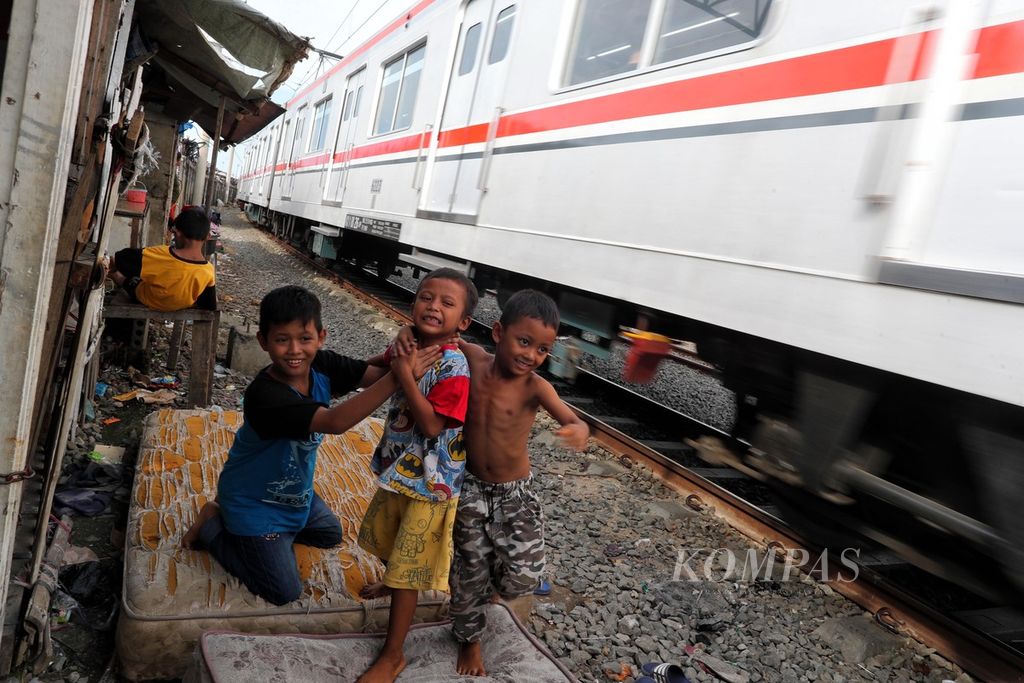 Anak-anak bermain di atas kasur bekas di tepi rel kereta api di kawasan hunian semi permanen padat penduduk, Pademangan, Jakarta Utara, jumat (18/6/2021). Kemiskinan memaksa anak-anak tersebut tumbuh dan bermain di tempat yang tak layak. 