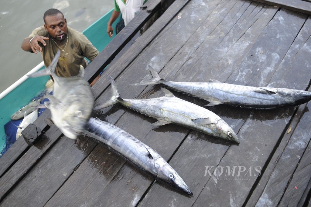 Pedagang ikan mengangkat ikan hasil tangkapan nelayan di Pasar Boswezen, Kota Sorong, Papua Barat, Sabtu (26/4/2014). Pasar tersebut merupakan tempat dijualnya hasil kekayaan laut Papua yang beraneka ragam.