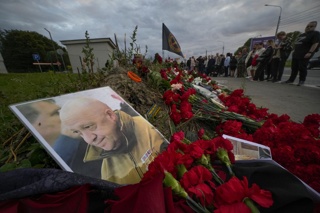 Foto pemimpin kelompok tentara bayaran Wagner, Yevgeny Prigozhin, diletakkan di antara bunga di markas pusat Wagner di St Petersburg, Rusia, 24 Agustus 2023. Prigozhin dilaporkan tewas dalam pesawat yang jatuh di utara Moskwa. 