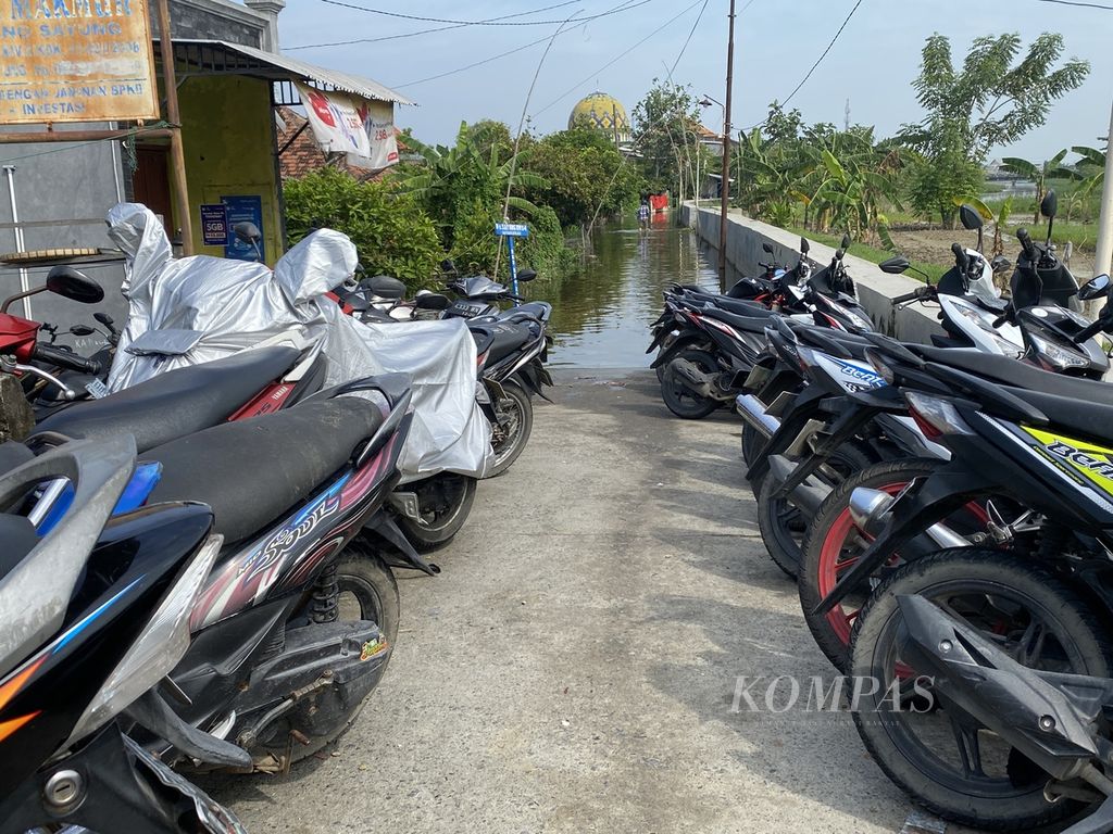 Deretan sepeda motor milik warga diparkir di atas jembatan di Desa Sayung, Kecamatan Sayung, Kabupaten Demak, Jawa Tengah, di tengah banjir, Rabu (10/4/2024). Warga sengaja memarkirkan kendaraan mereka di lokasi itu karena rumah dan lingkungan mereka terendam banjir. 