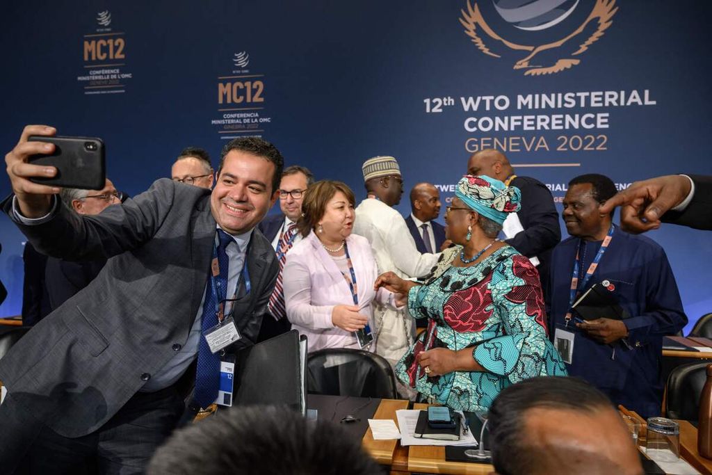 Anggota delegasi merayakan kesepakatan yang dicapai Organisasi Perdagangan Dunia atau WTO dengan memberi selamat kepada Direktur Jenderal WTO Ngozi Okonjo-Iweala (tengah) setelah upacara penutupan Konferensi Tingkat Menteri WTO di Kantor Pusat WTO di Geneva, Swiss, Jumat (17/6/2022). 