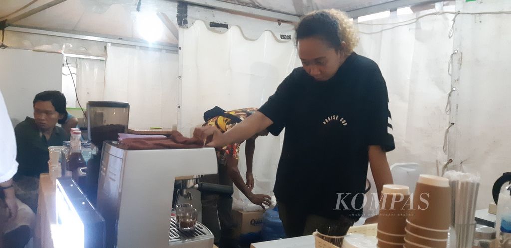 Lita Numberi, salah satu pemilik Kafe Meja Kopi, sedang membuat pesanan kopi salah seorang pembeli di tengah acara Irian Creative Week di Kota Jayapura, Papua, Minggu (5/3/2023).