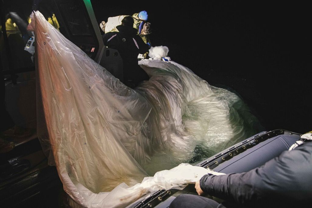 Foto dari Angkatan Laut AS ini menunjukkan para pelaut yang ditugaskan ke Explosive Ordnance Disposal Group 2 untuk mengambil balon pengintai di lepas pantai Pantai Myrtle, South Carolina, di Samudra Atlantik pada 5 Februari 2023.