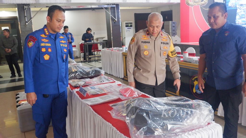 Wakil Kepala Kepolisian Daerah Kalimantan Selatan Brigadir Jenderal  (Pol) Rosyanto Yudha Hermawan (tengah) melihat barang bukti tindak pidana pembajakan kapal di Banjarmasin, Jumat (16/2/2024). 