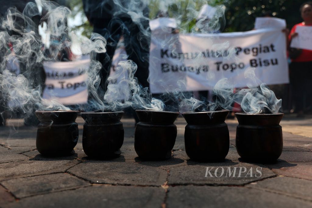Asap kemenyan mengepul di antara warga yang mengadakan aksi <i>tapa bisu</i> di depan rumah dinas Wali Kota Surakarta Gibran Rakabuming Raka di Loji Gandrung, Jalan Slamet Riyadi, Kota Surakarta, Jawa Tengah, Senin (16/10/2023).