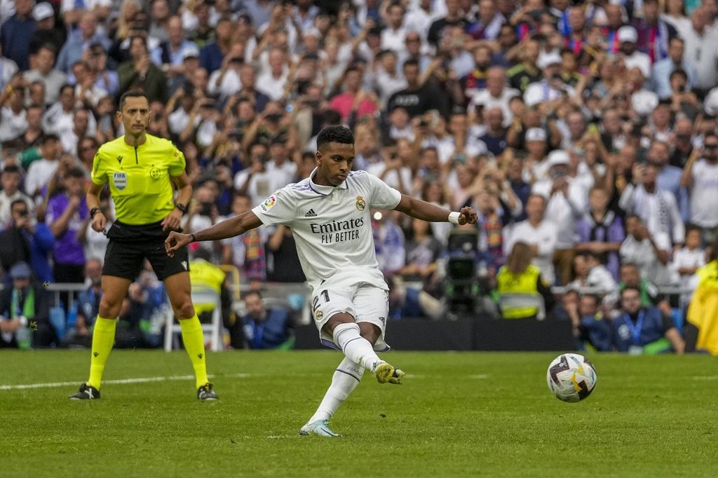 Pemain Real Madrid Rodrygo mencetak gol ke gawang Barcelona melalui titik penalti pada laga Liga Spanyol di Stadion Santiago Bernabeu, Madrid, Minggu (16/10/2022). Pada laga itu, Madrid menang 3-1. 